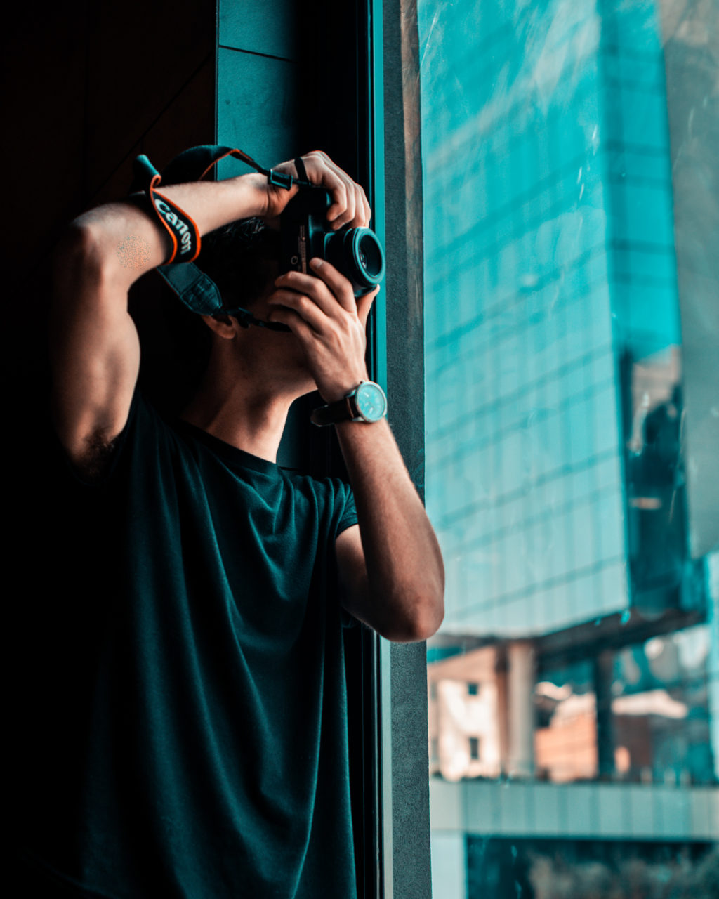 Man taking a photo out of a window