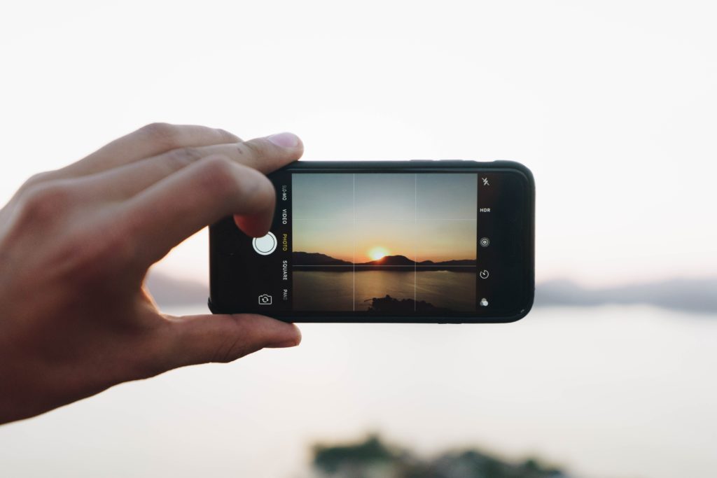 Photo of mobile phone taking photo of sunset