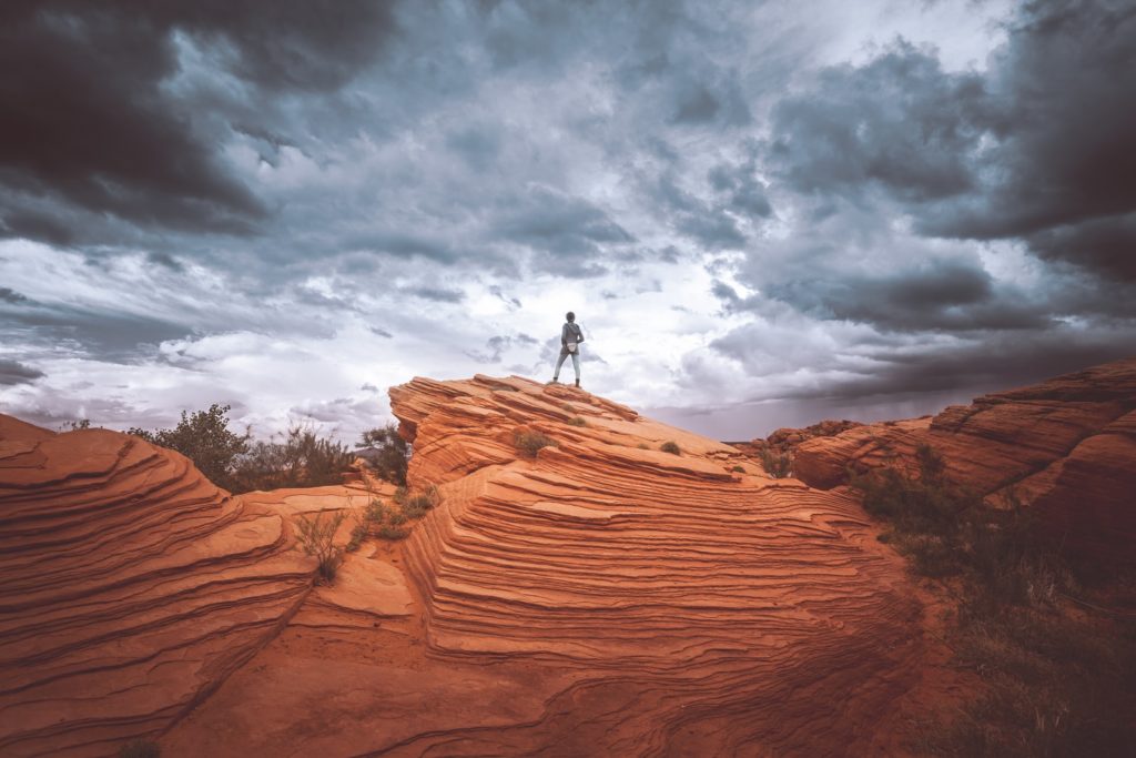 person standing on brown rock formation during daytime