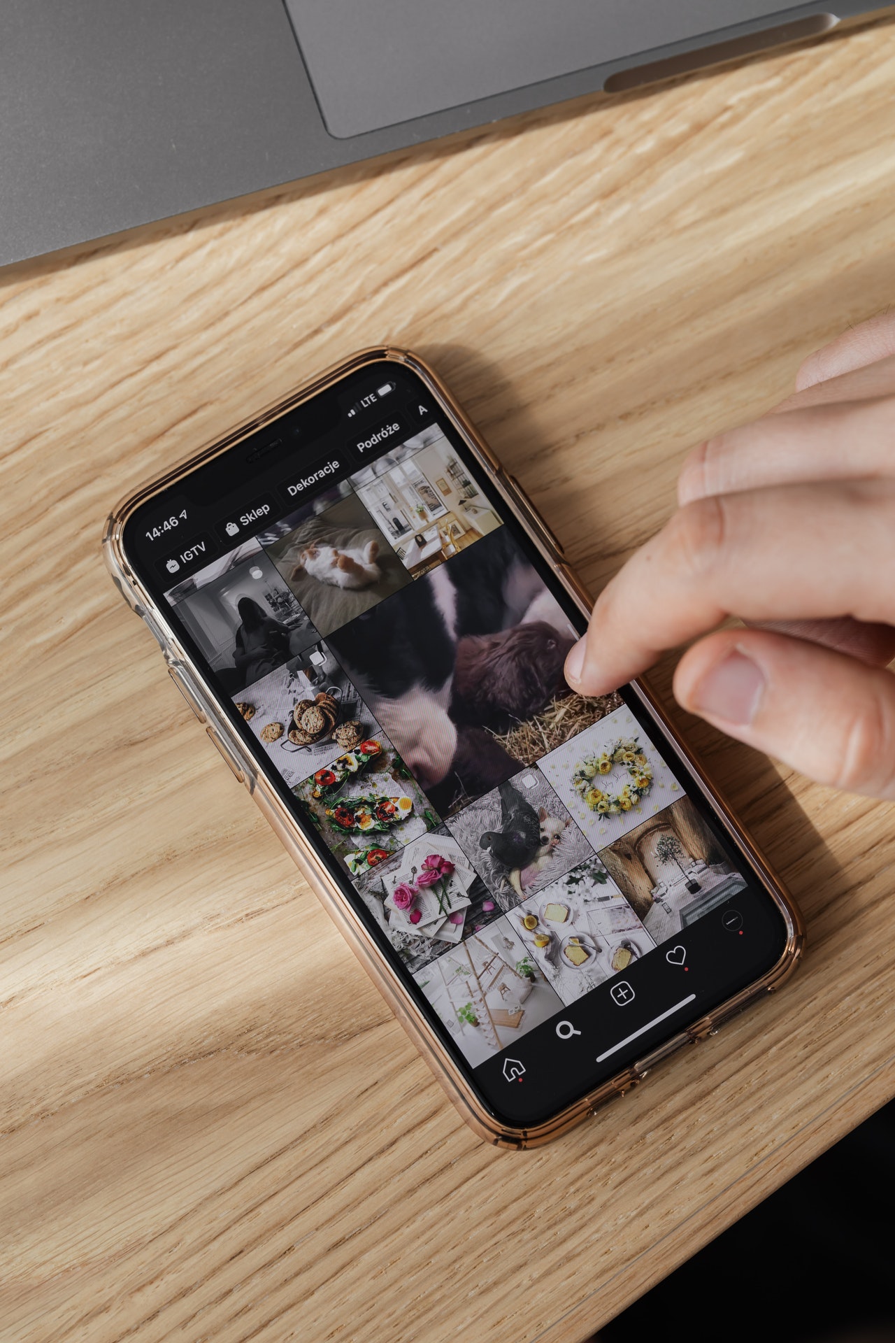 crop person browsing smartphone on wooden table