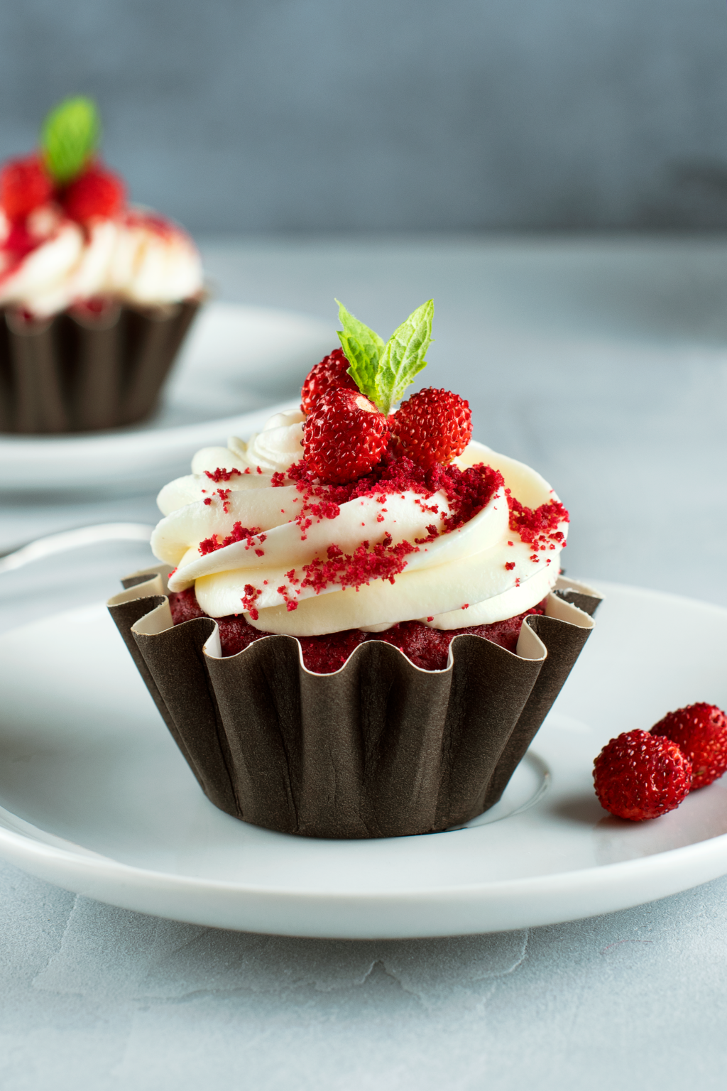 a cupcake with whipped cream and strawberries