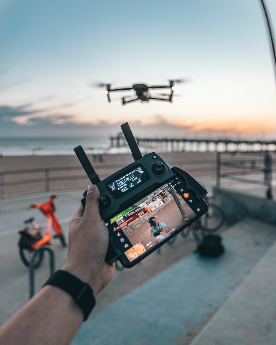 man flying a drone while holding remote