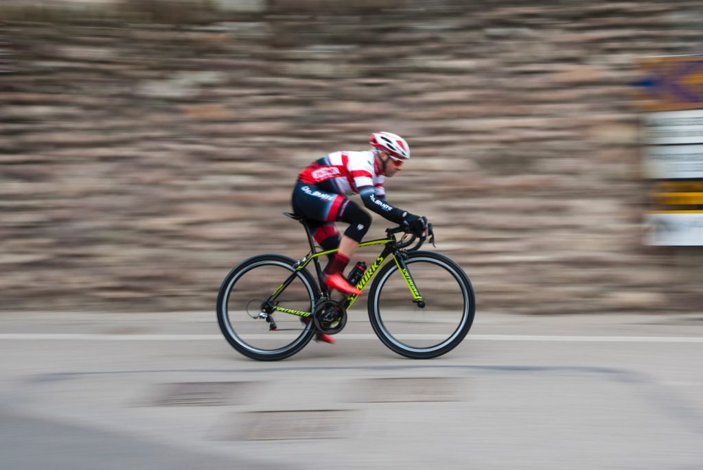 man riding green and black road bike during daytime