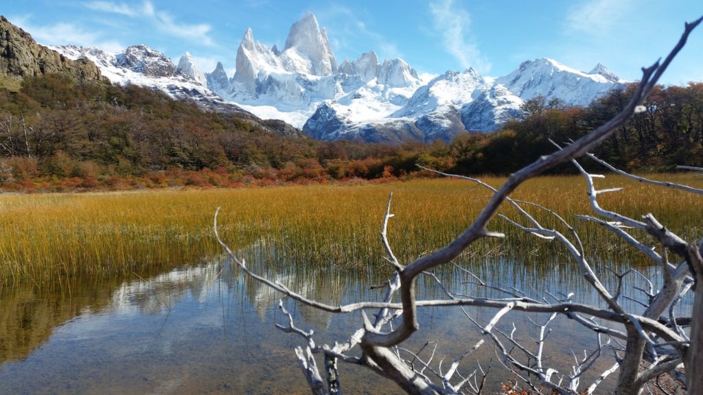 landscape photography of body of water viewing mountain under blue and white sky