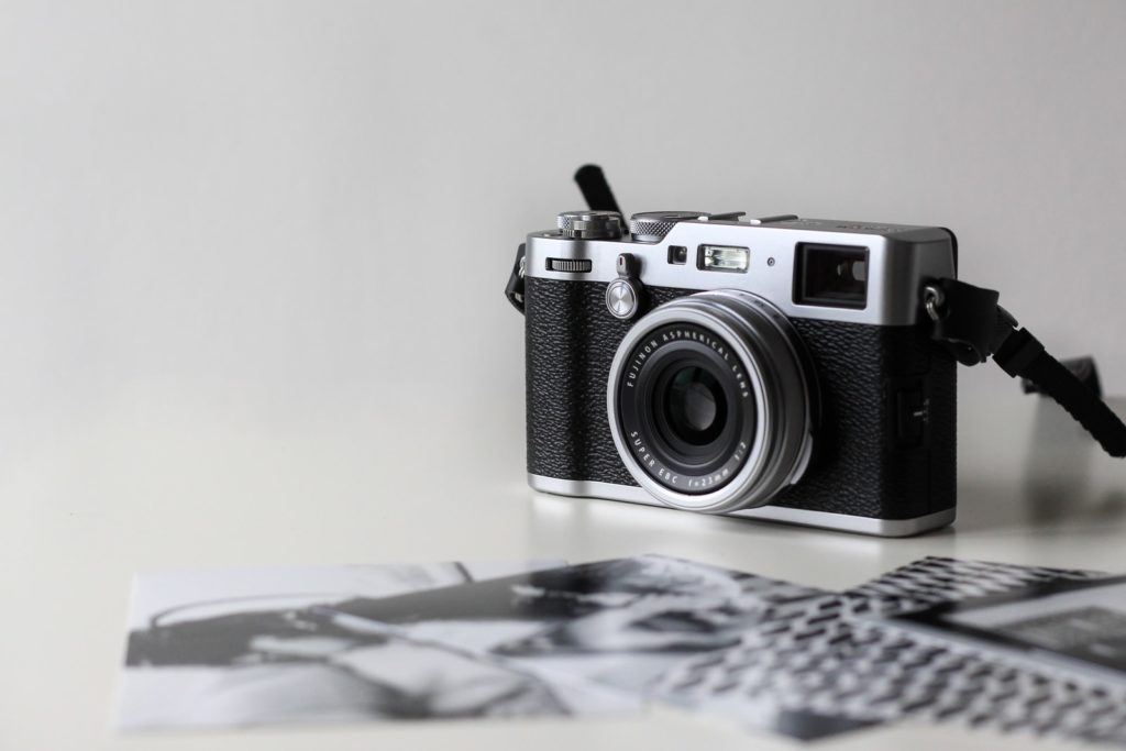black and gray film camera near printed photos photo project