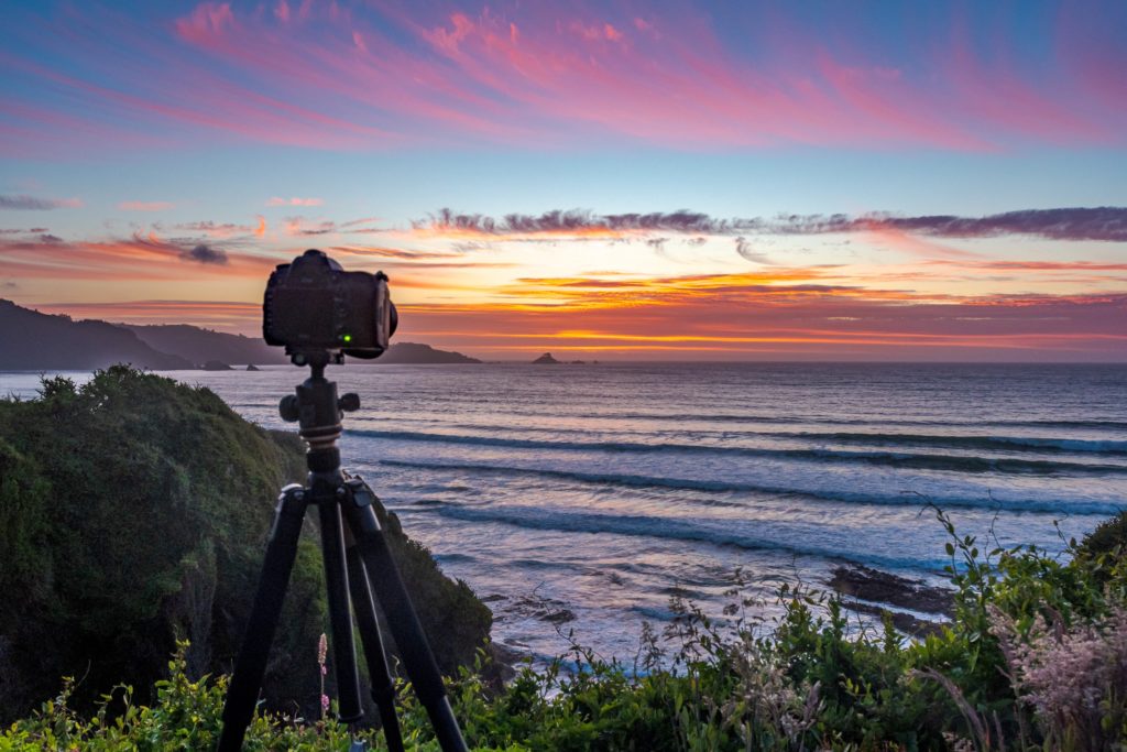 Camera on tripod looks out towards sunset