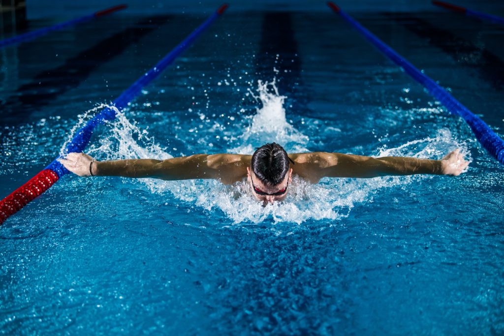 Man swimming butterfly stroke. 