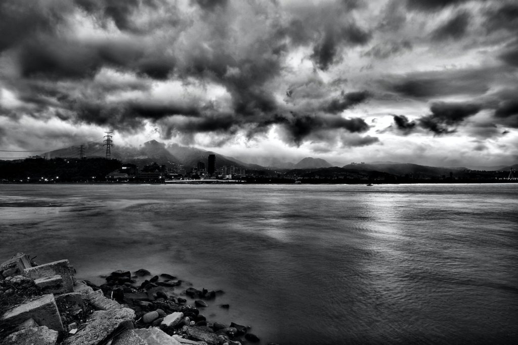 grayscale photo of sea during cloudy sky at daytime