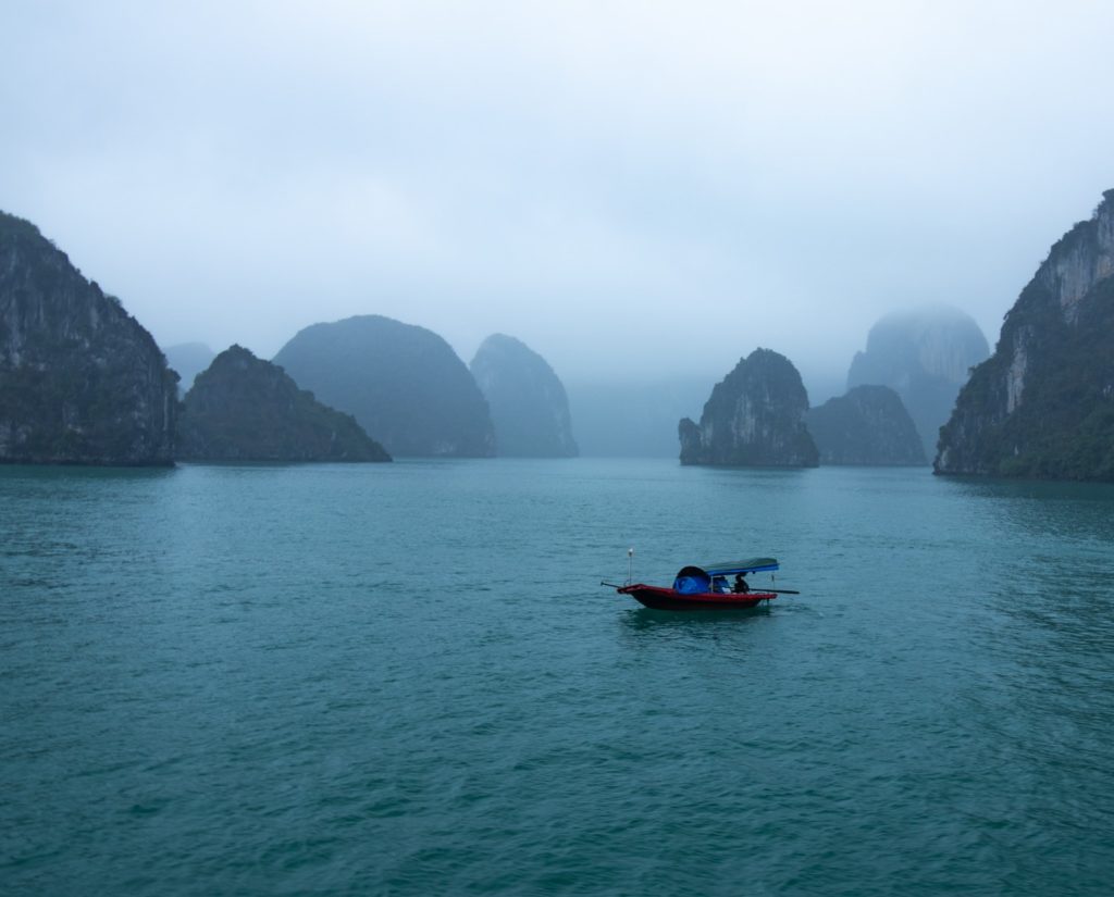 blue and red boat on body of water