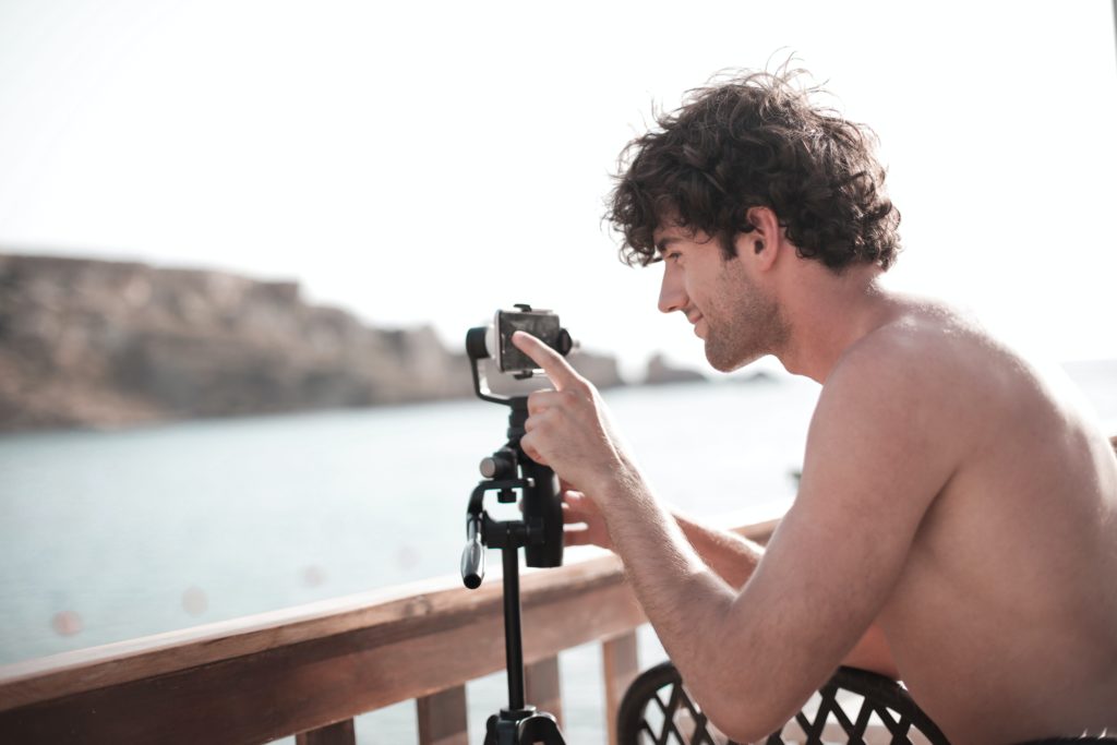 happy man taking shot of landscape on balcony against