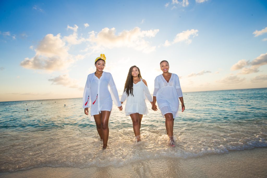 Three people on a beach lit by fill flash