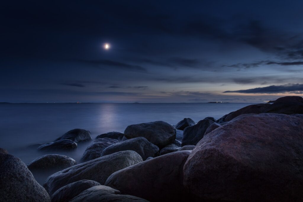 A blue hour seascape image lit by moonlight