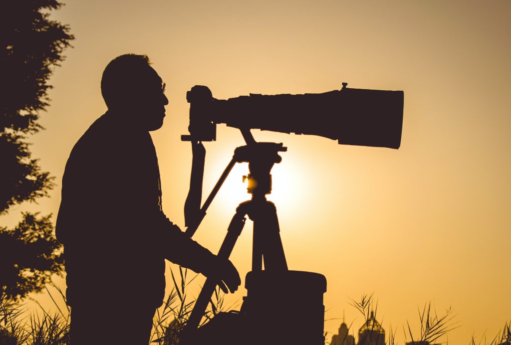 silhouette of photographer with long lens upgrades