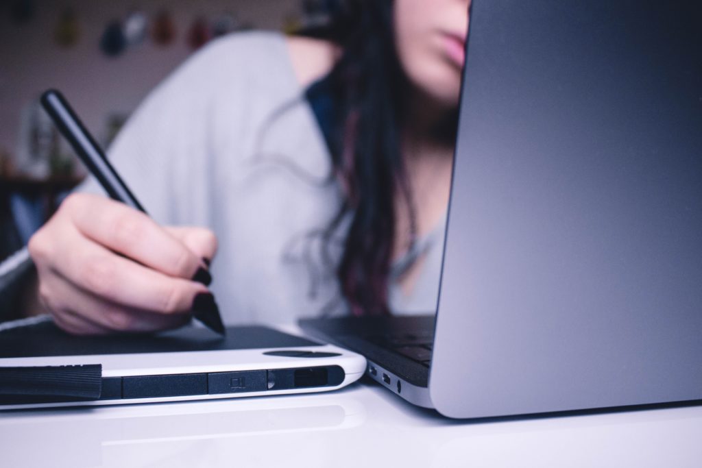 woman using graphics tablet on laptop 