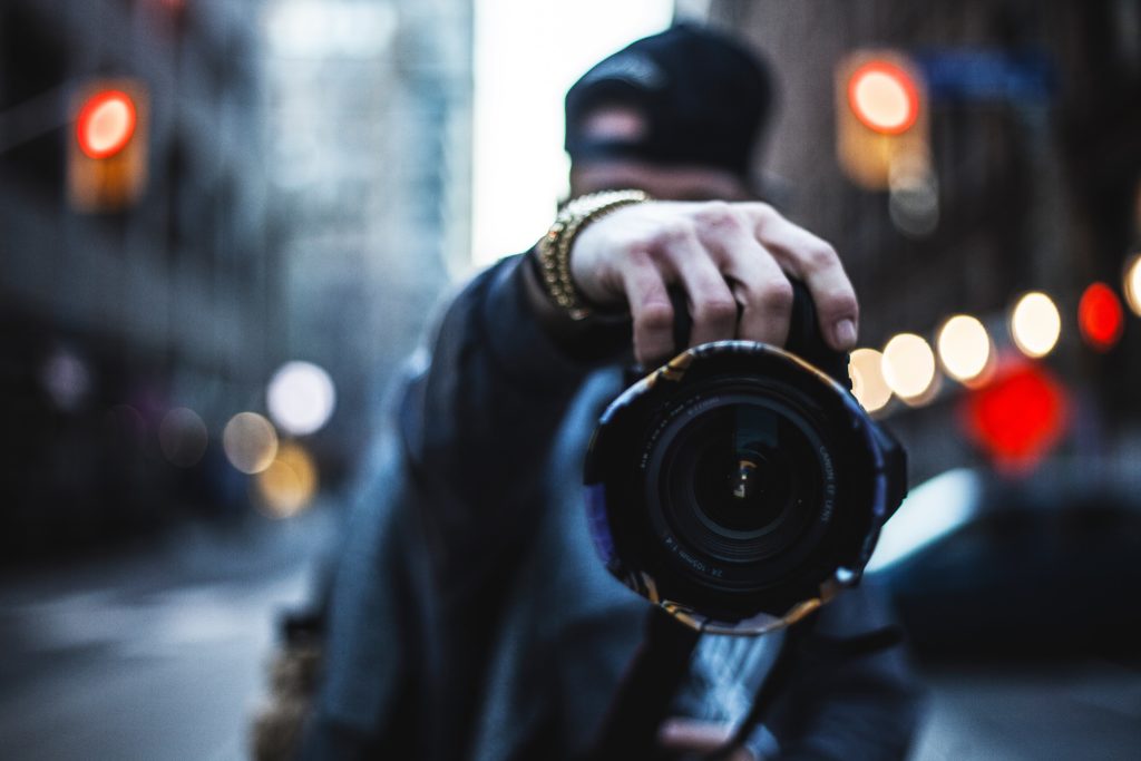 Photographer holding camera out.