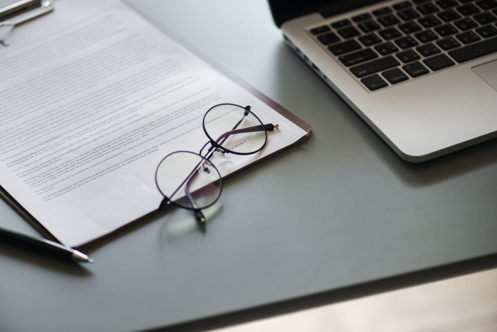 Glasses, Apple Mac, pen and contract on a table