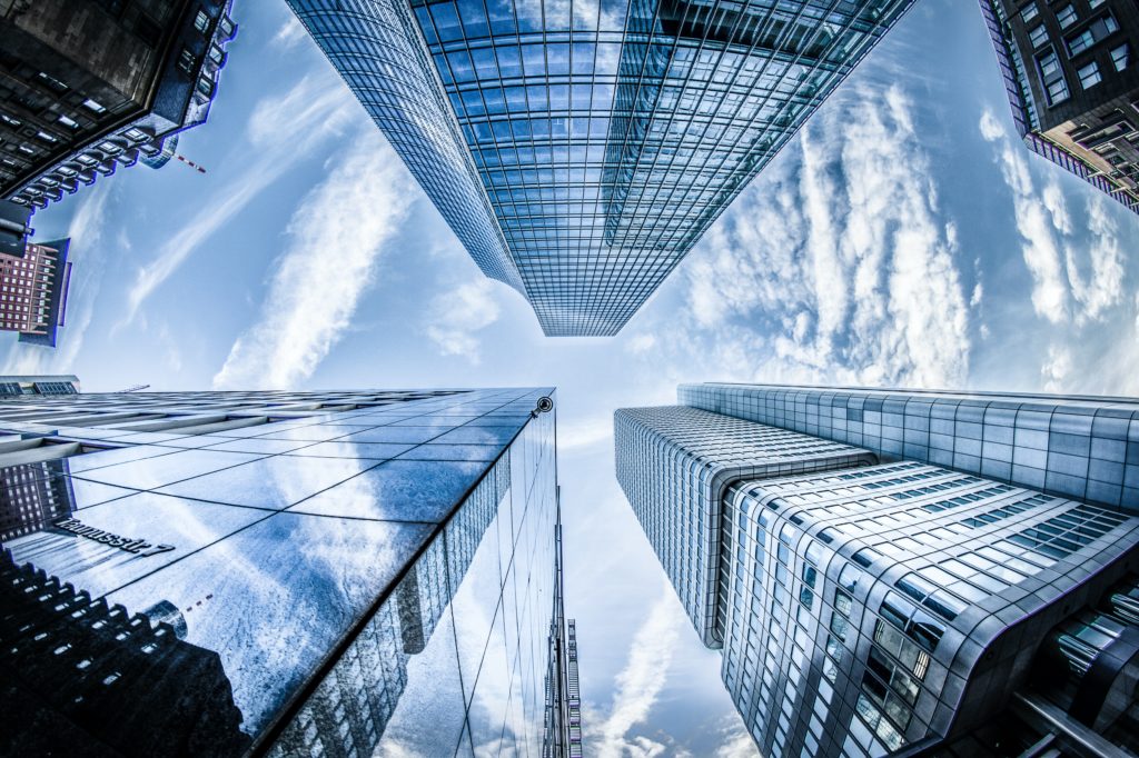 low angle photo of four high rise curtain wall buildings