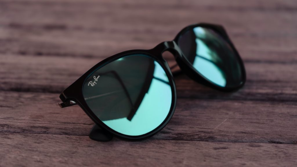 black framed sunglasses on brown wooden table