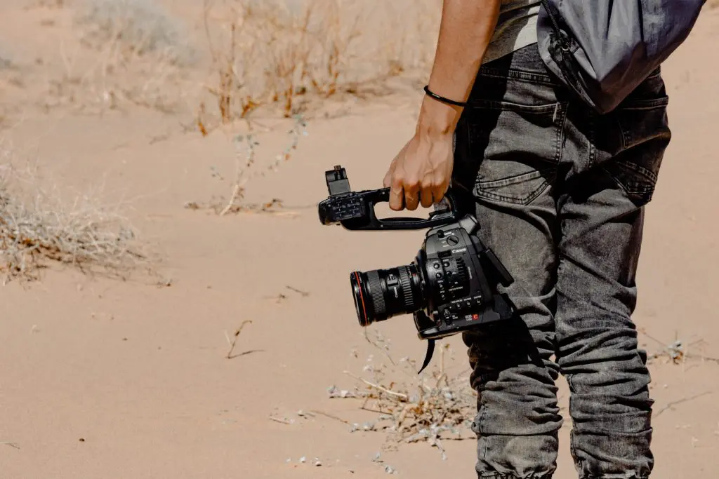 man standing and holding dslr camera