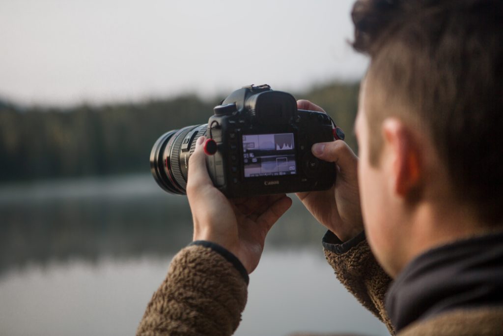 Man holding camera looking at live view