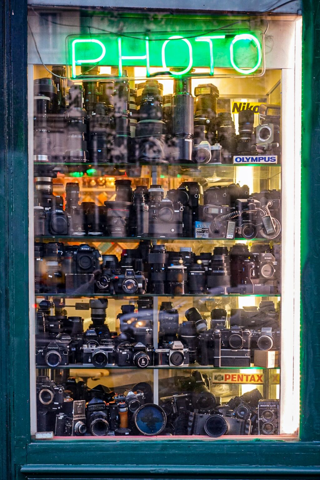 Window of a cmaera store with lots of equipment on display 