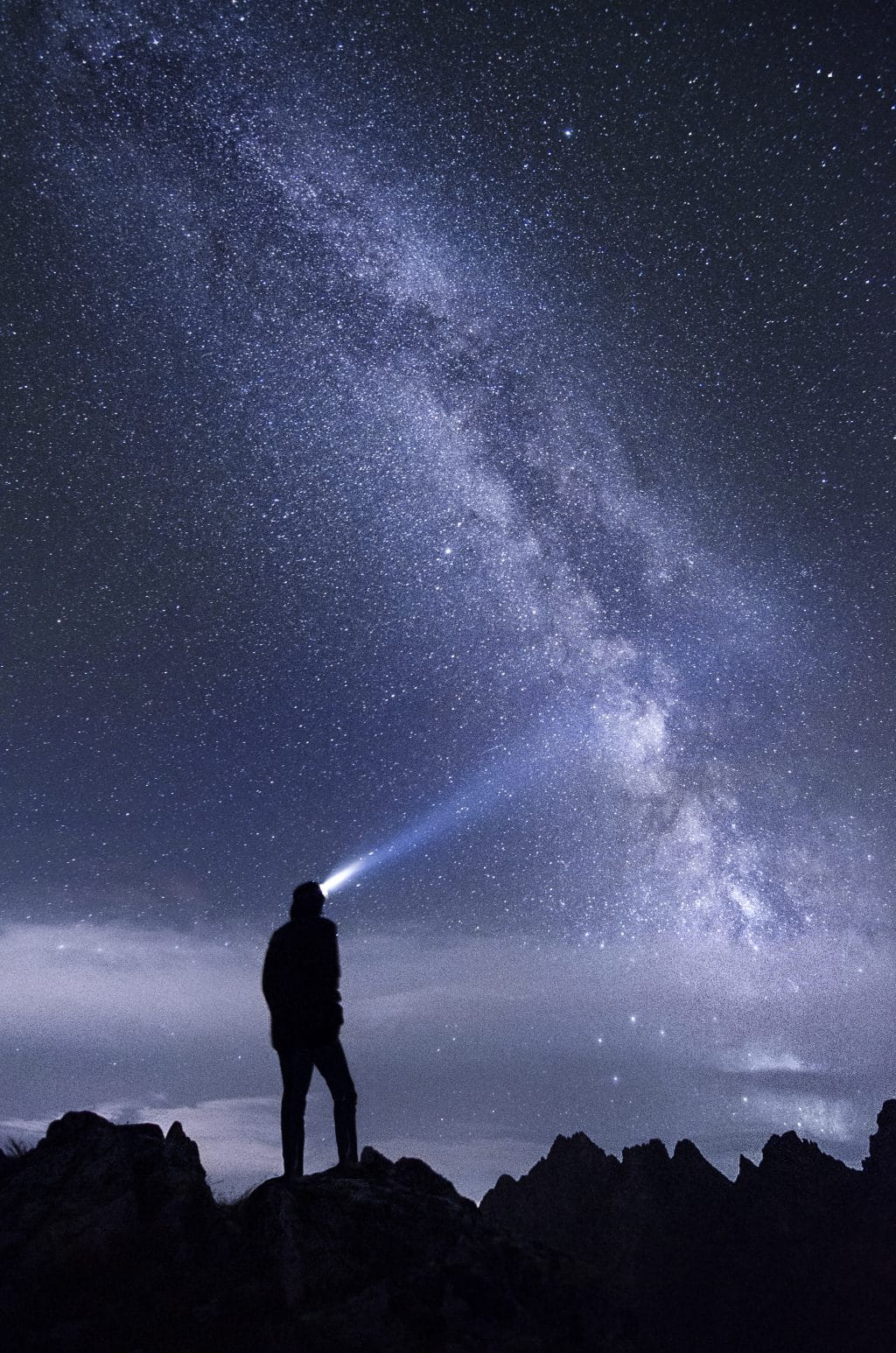 Man with torch in front of Milky Way
