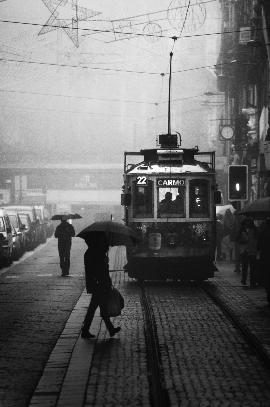 monochrome photo of people walking near tramway