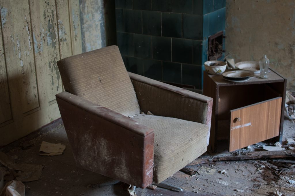 Abandoned armchair in derelict house
