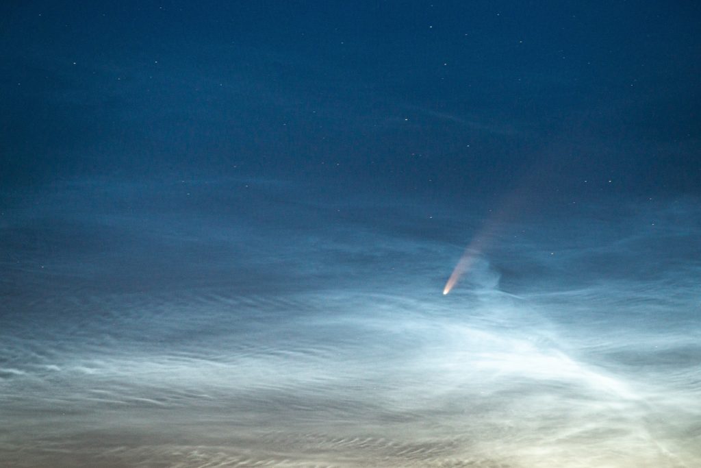 Neowise behind white clouds and blue sky