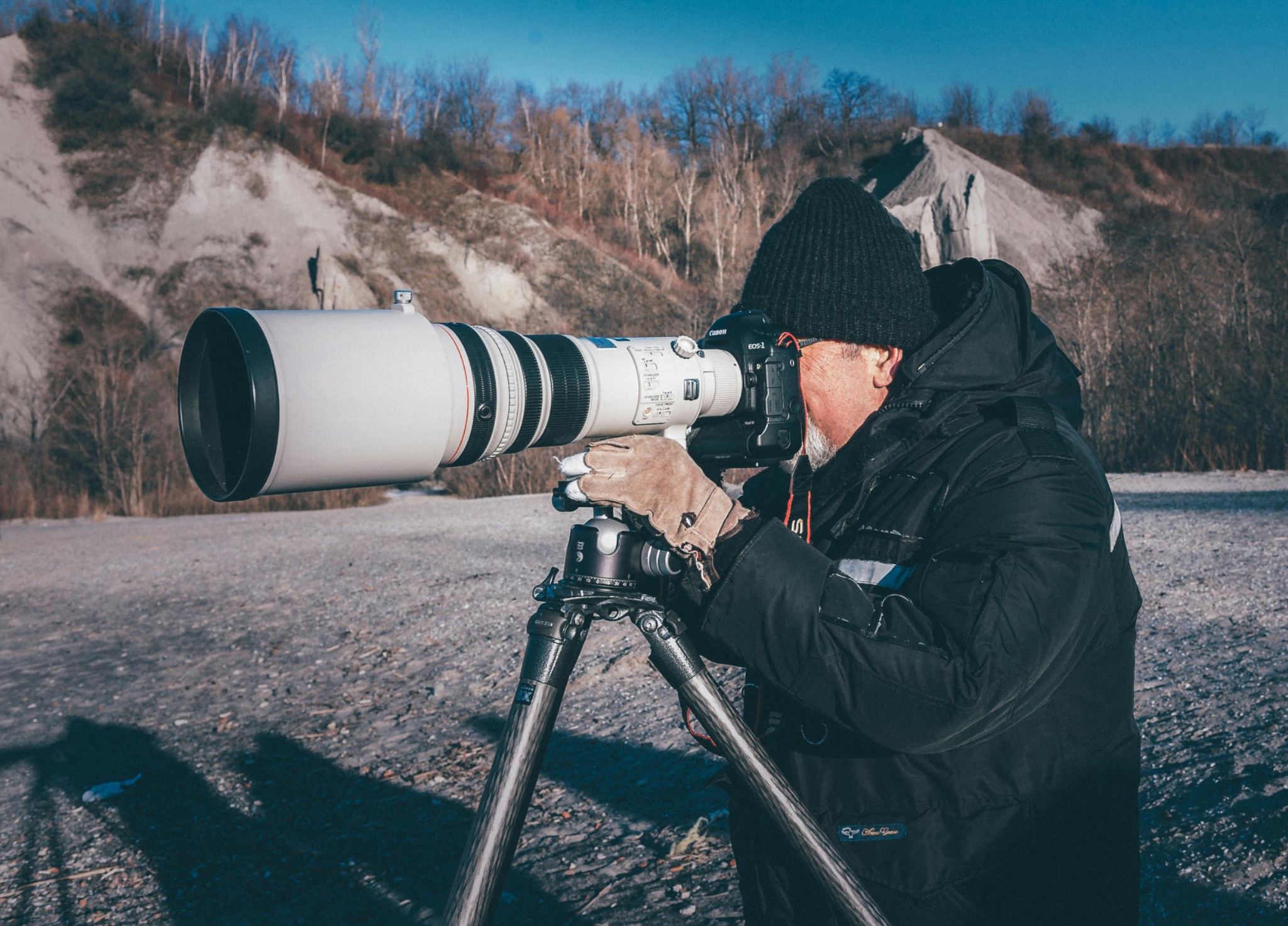 Outdoor photographer with large telephoto lens and camera on a tripod