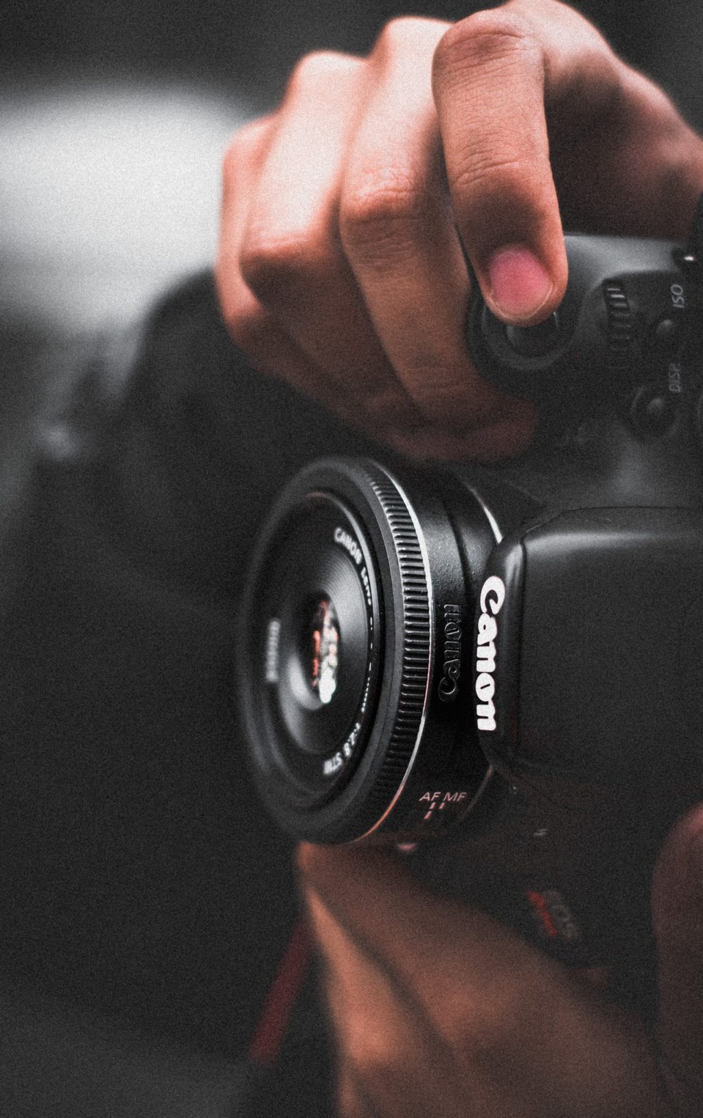 person holding black canon dslr camera shallow focus