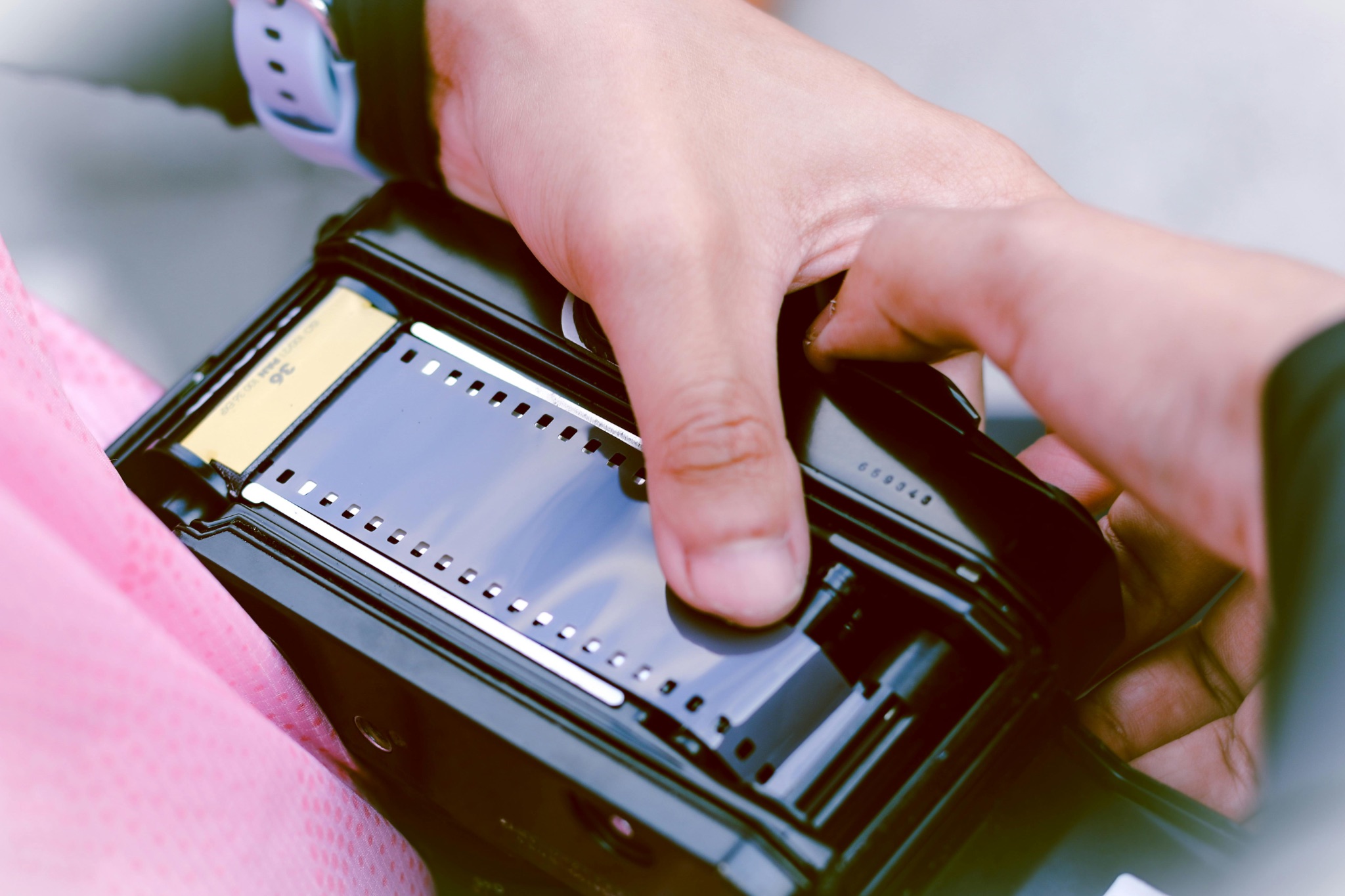Person loading a 35mm film into a camera