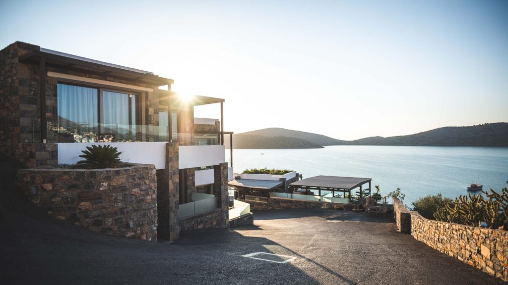 a house with a view of the sea and the mountains in the background