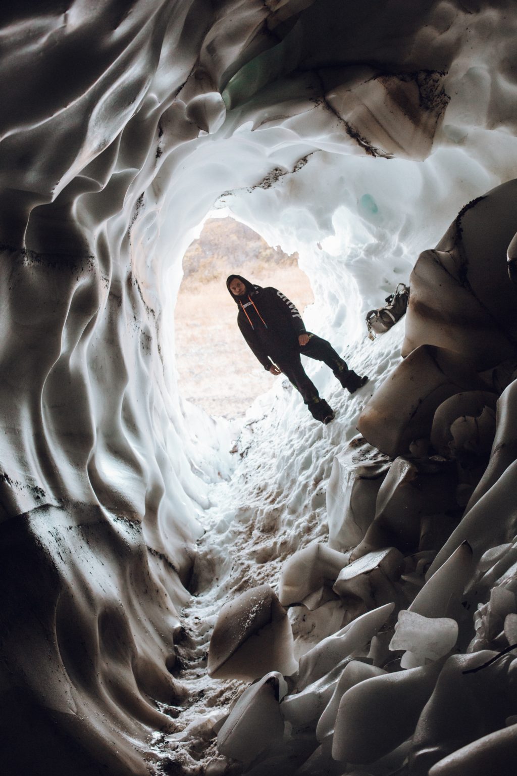 Dramatic Dutch Angle shot of man inside ice cave. 