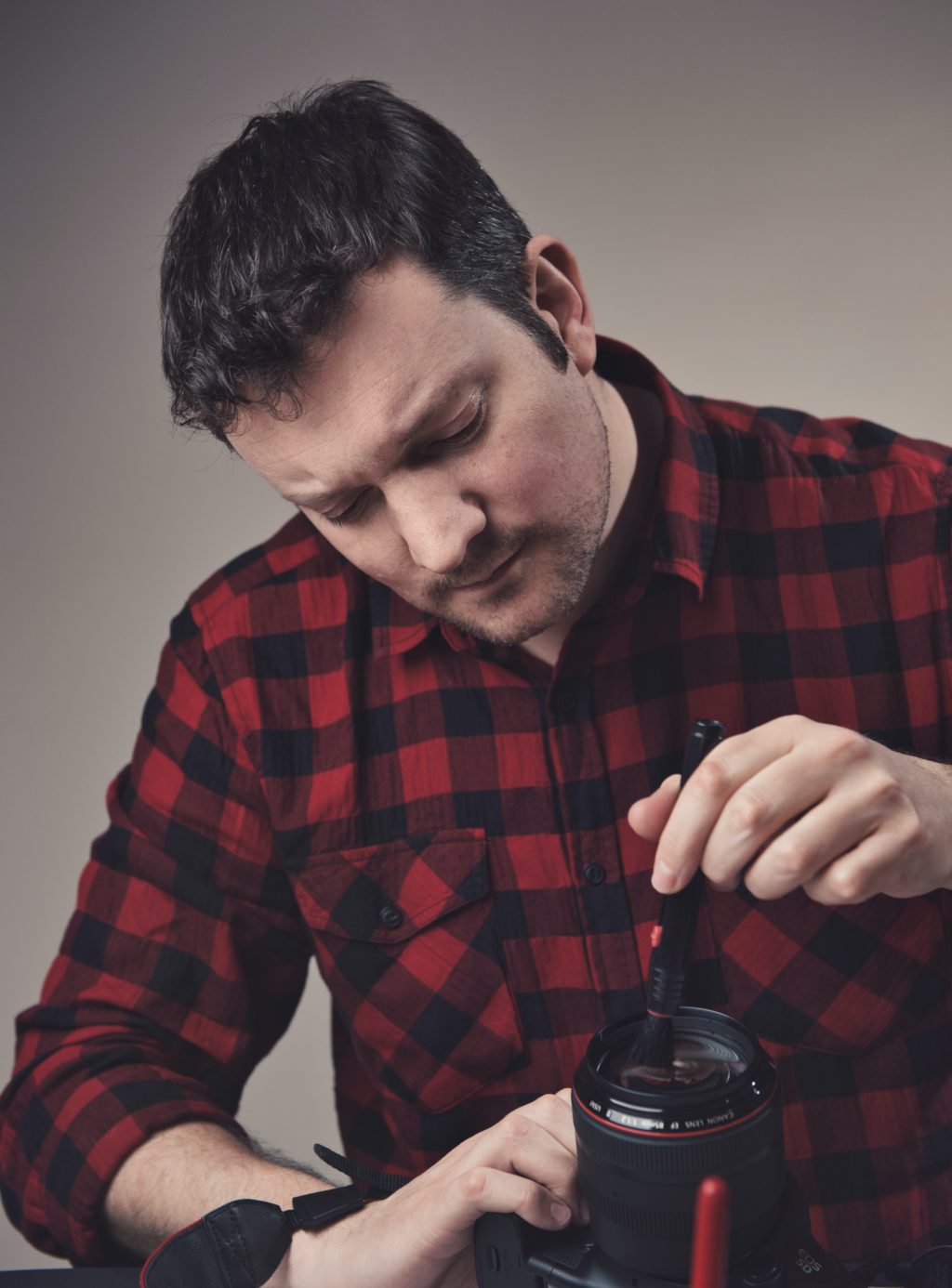 man cleaning camera lens.