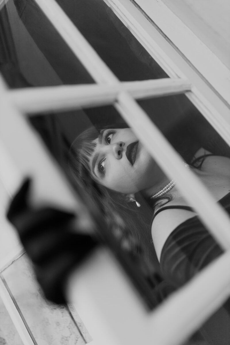 A woman looking out of a window with a bow