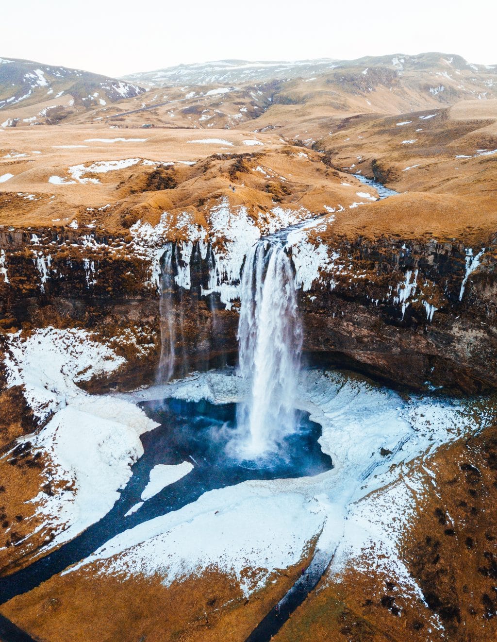 Waterfall into icy lake