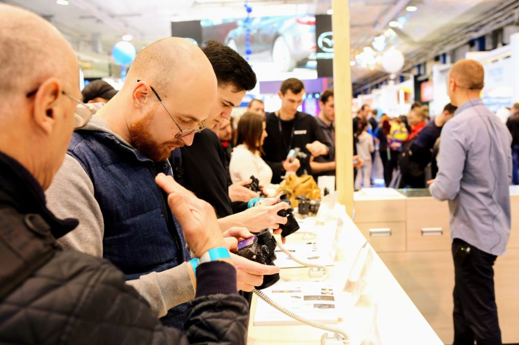 Photographers looking ar cameras in a store