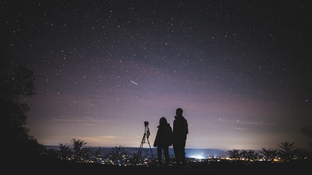 silhouette of two person standing during nighttime