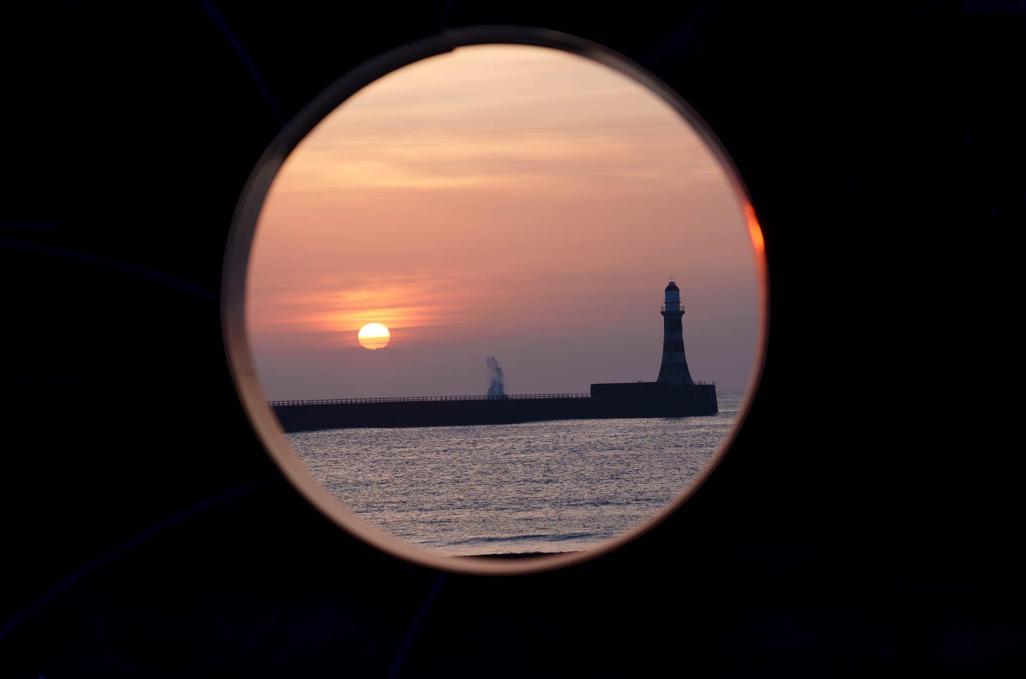 Sunrise at Roker Lighthouse seen through the C2C monument