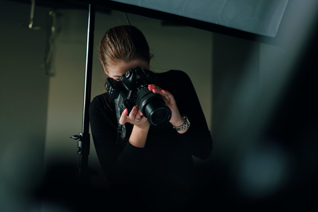 Young woman taking photograph in a studio setting 