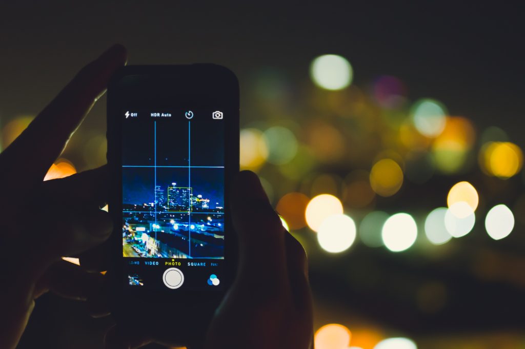 photo of phone taking image of city at night