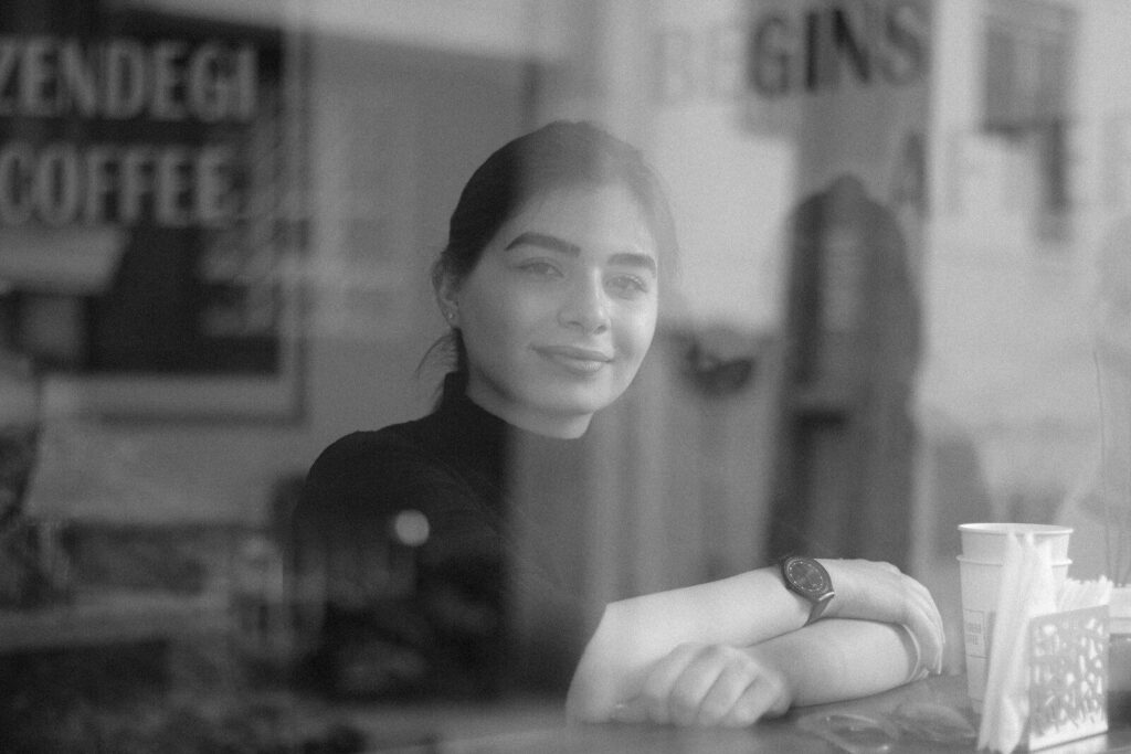 A woman sitting at a table in front of a window