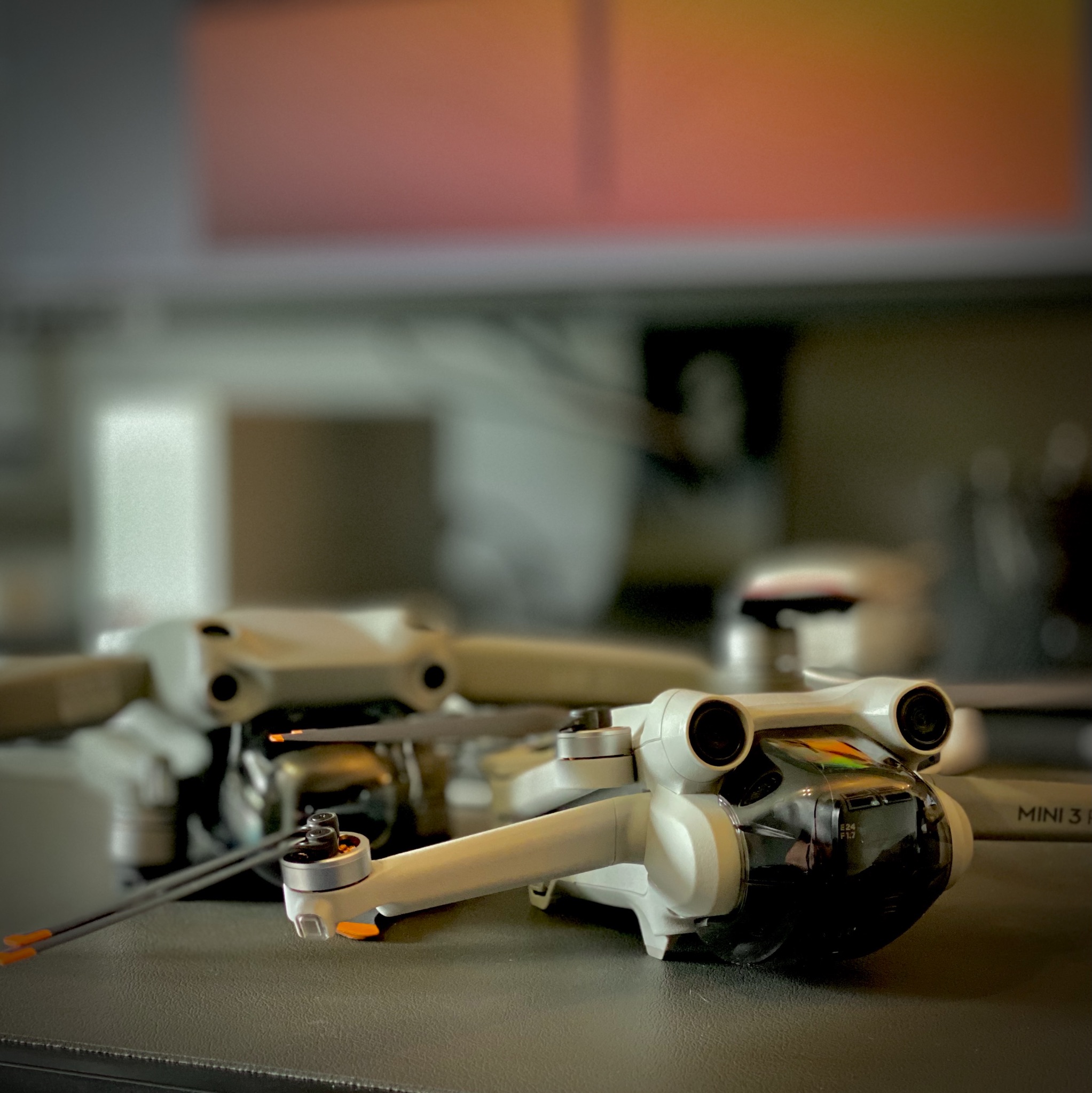 Two DJI drones, an Air 2s and a Mini 3 Pro sitting on a table 