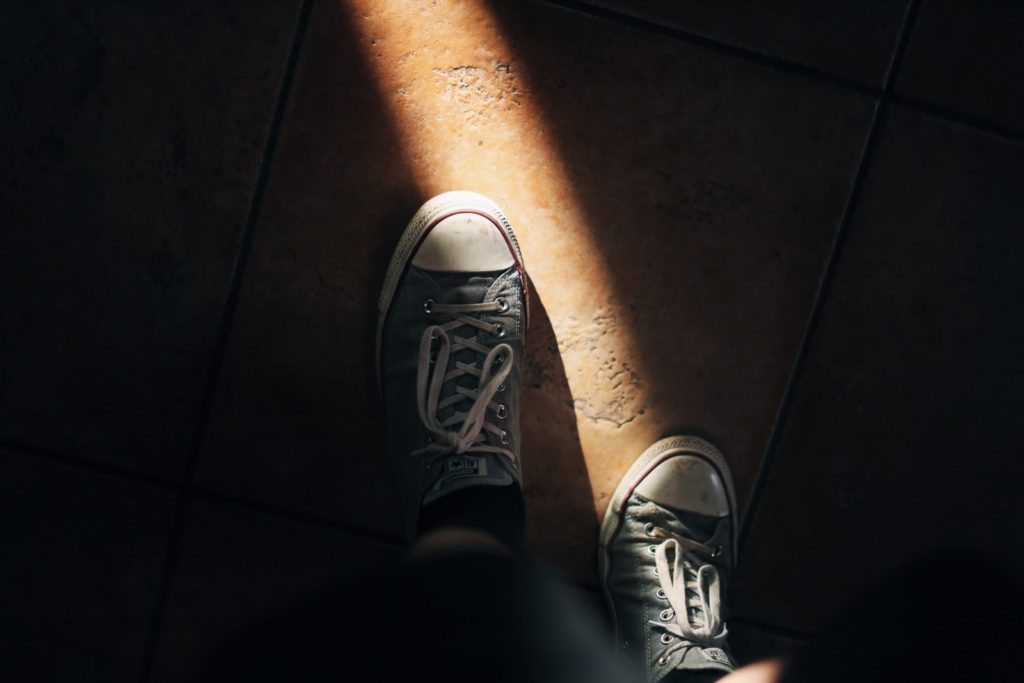 person wearing gray and white converse all star high top sneakers