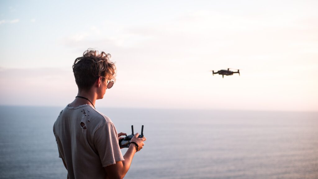 Man flying a drone near the coast