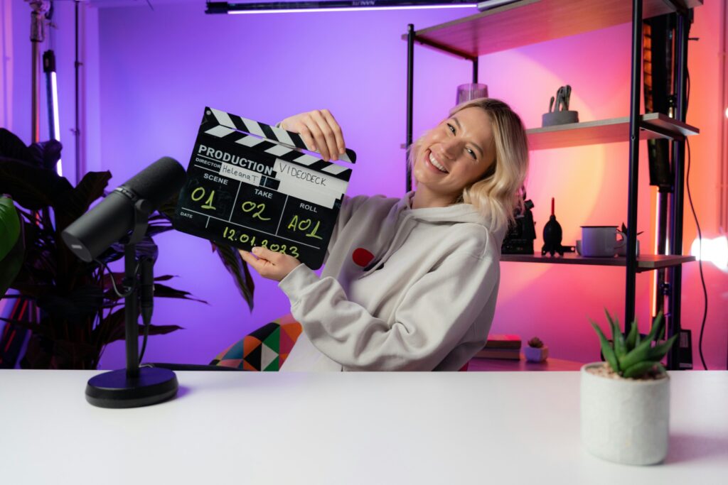 Woman holding a clapper board in a home studio