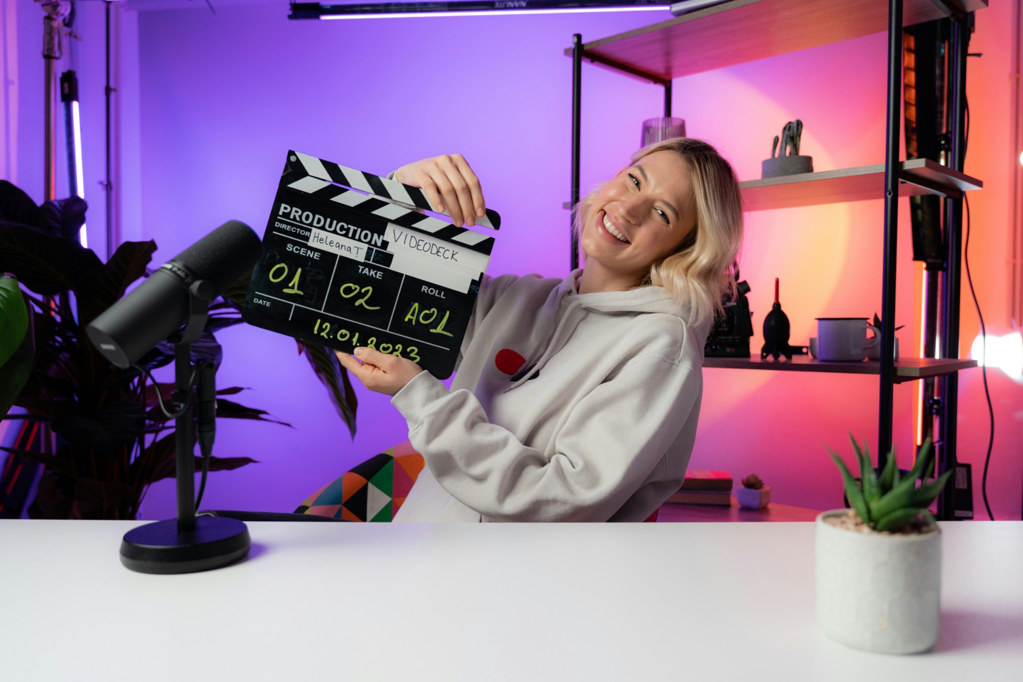 Woman holding a clapper board in a home studio