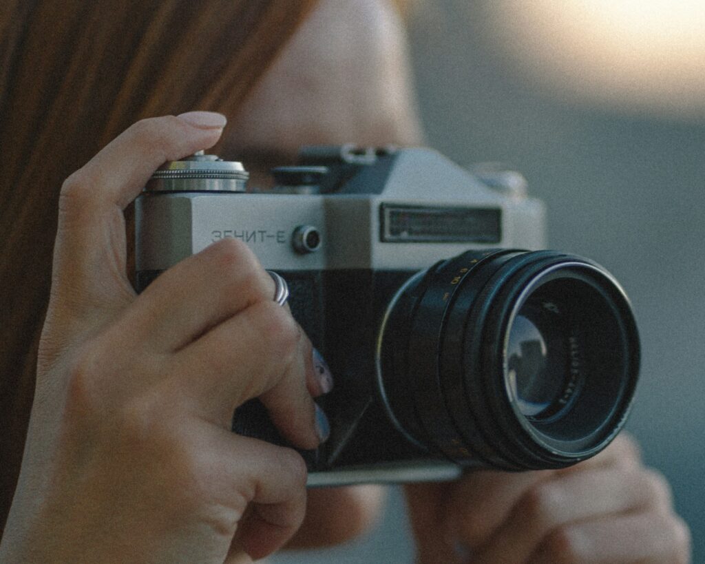 Woman taking photos with a Zenit film camera