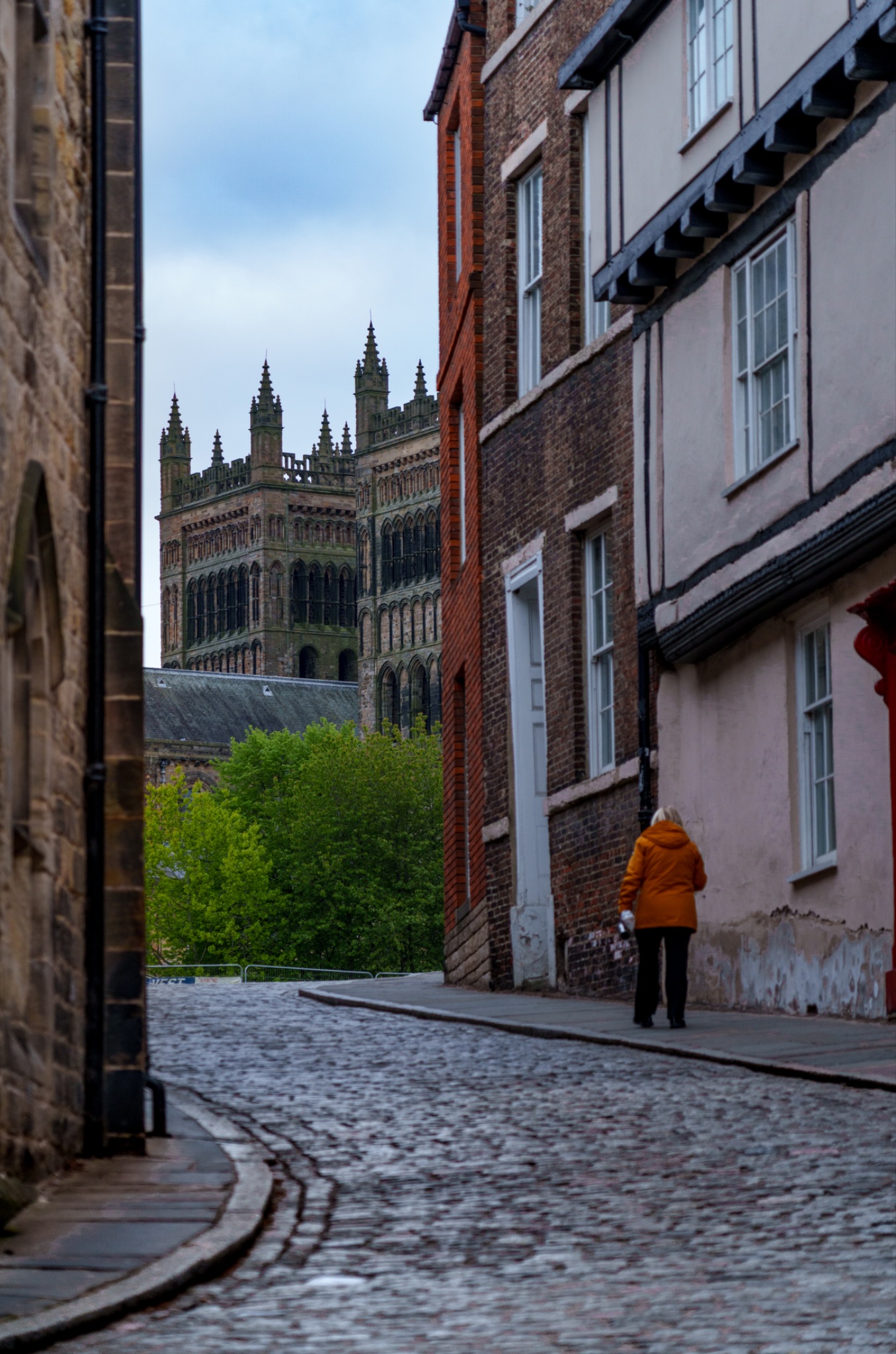 Woman walks up cobbled street towards Durham Cathedral